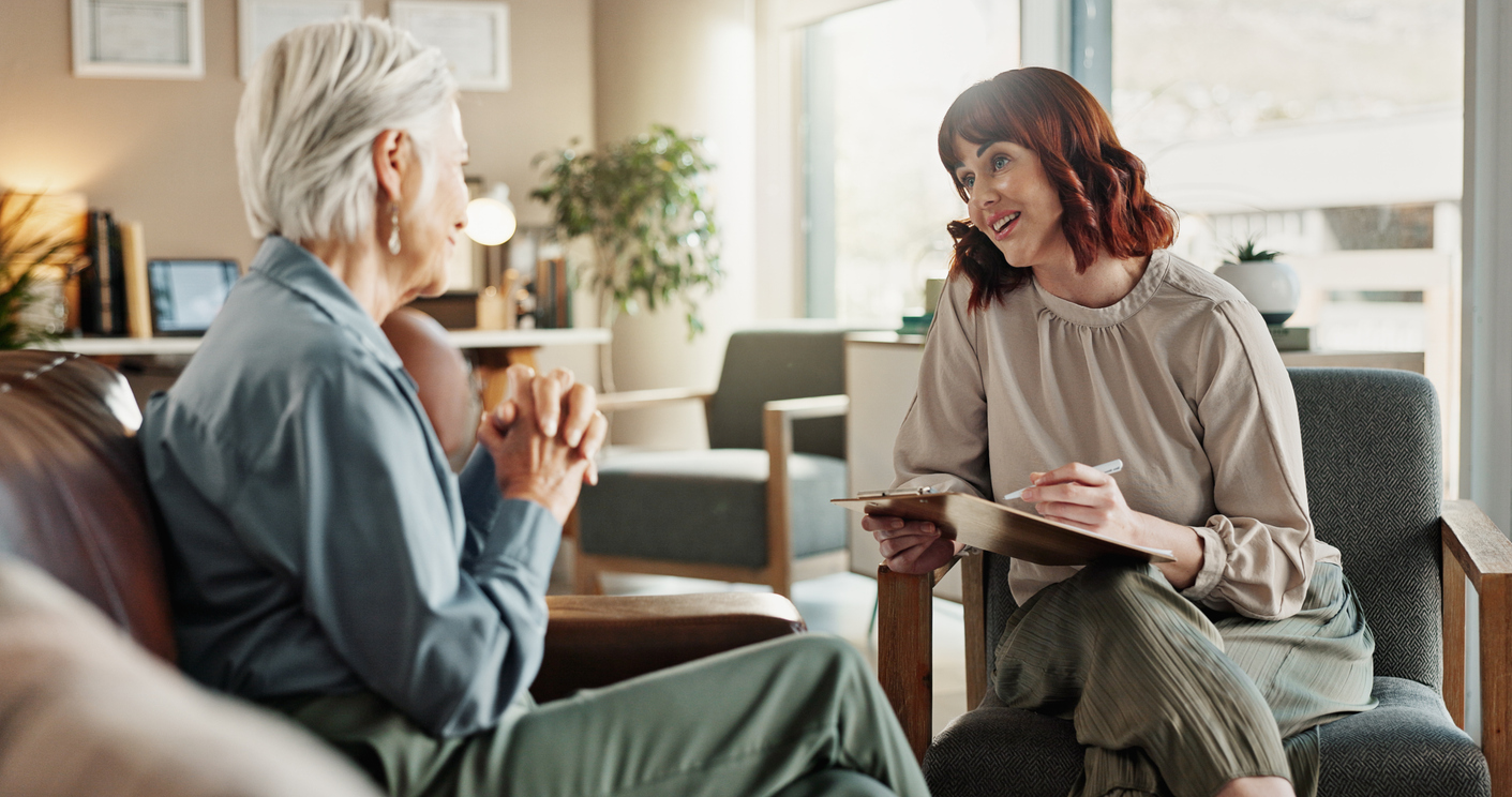 Senior woman, psychologist and clipboard for counselling, help and smile for support in office. Therapist, document and checklist for advice, listen or empathy for retirement mental health meeting